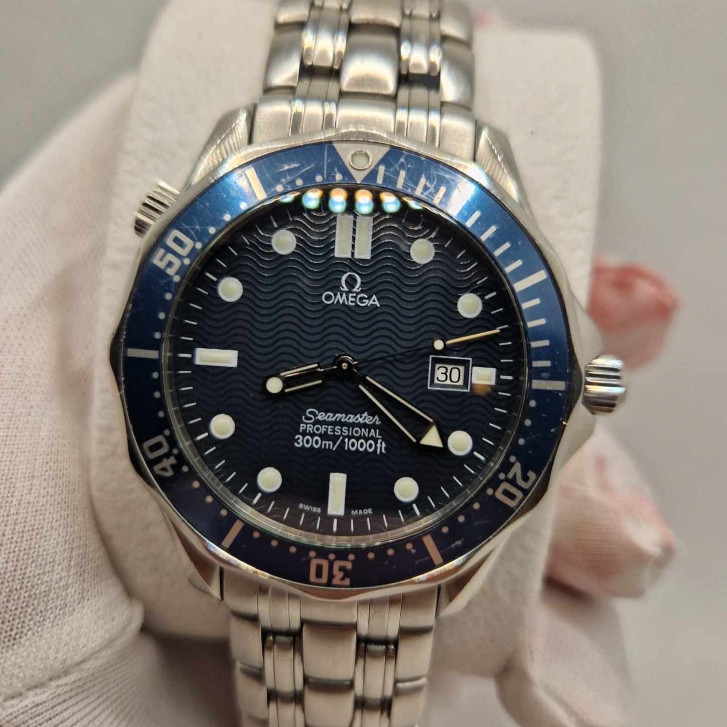 A close-up of the Omega Seamaster "GoldenEye" Quartz 2541.80.00 showcasing its captivating wave-pattern blue dial and illuminating hour markers.